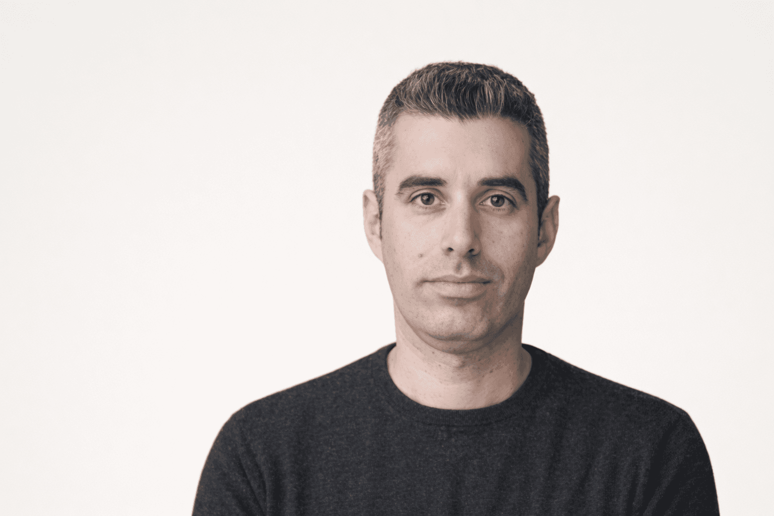 Black and white portrait of a smiling person with curly hair