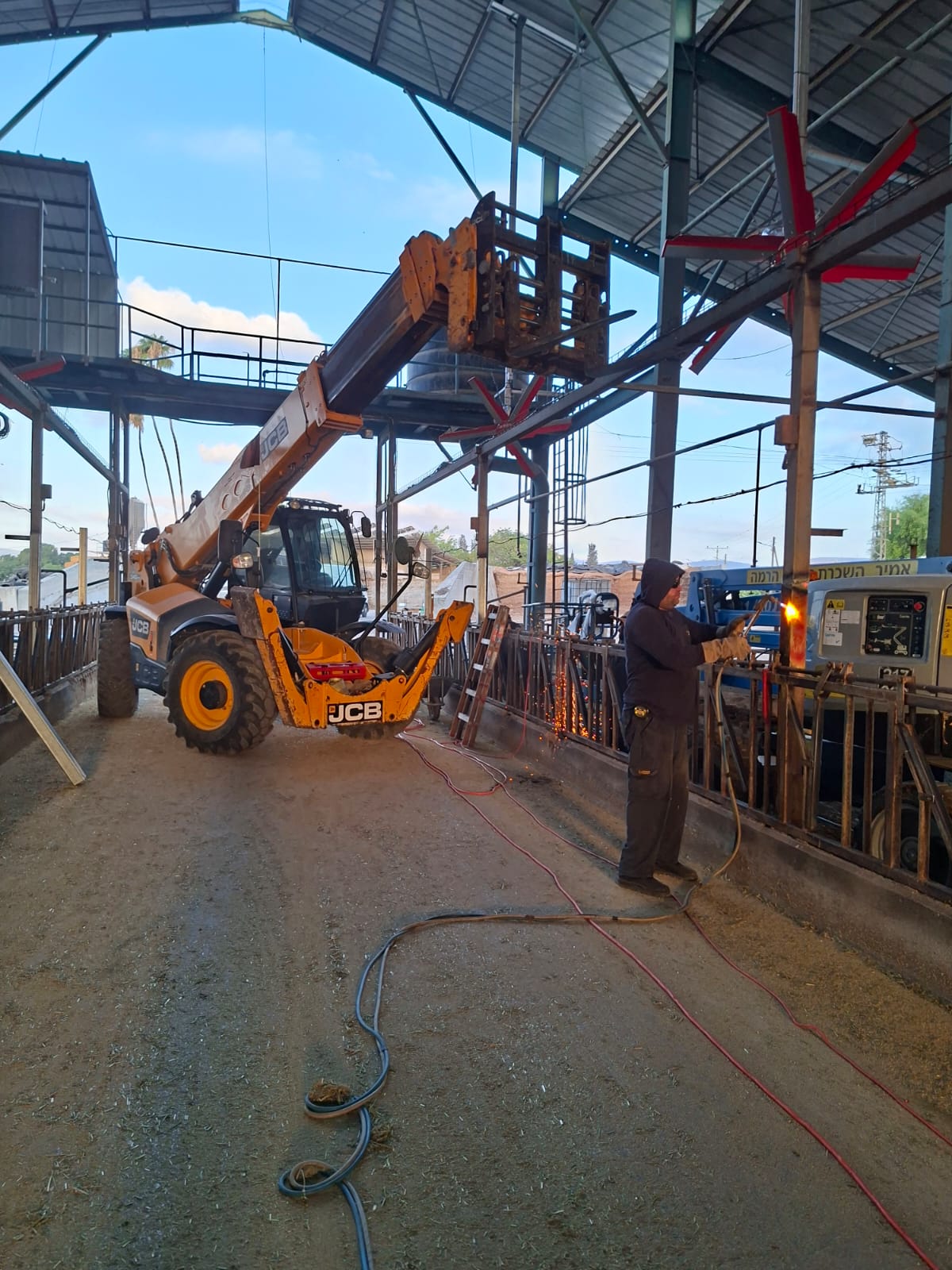 Spacious, luxurious living room with high ceilings, an elegant beige sectional sofa, warm ambient lighting, classical artwork, and rustic architectural elements, featuring an open layout with a view of a mezzanine level.