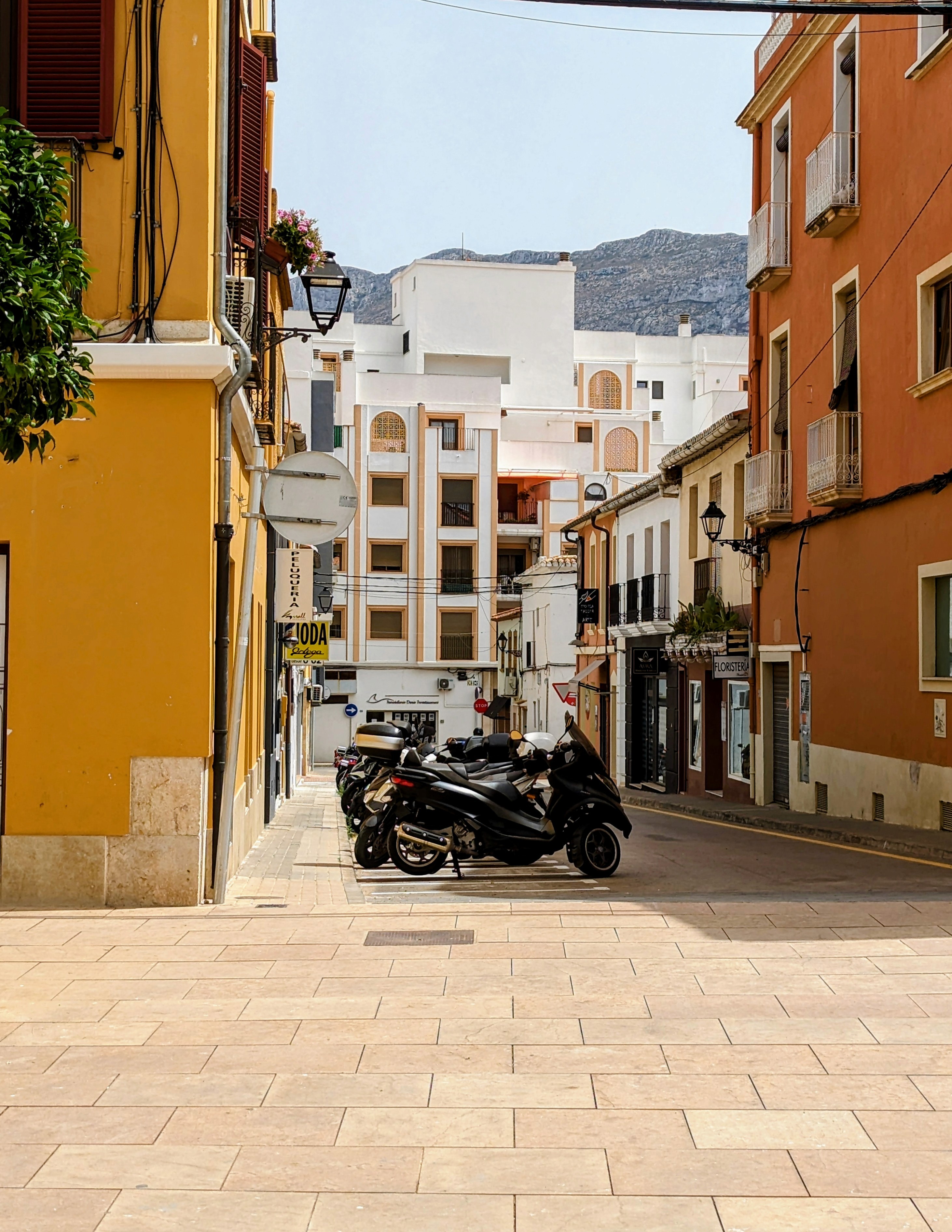 A photo of a series of bikes parked on a road in Denia, Spain.