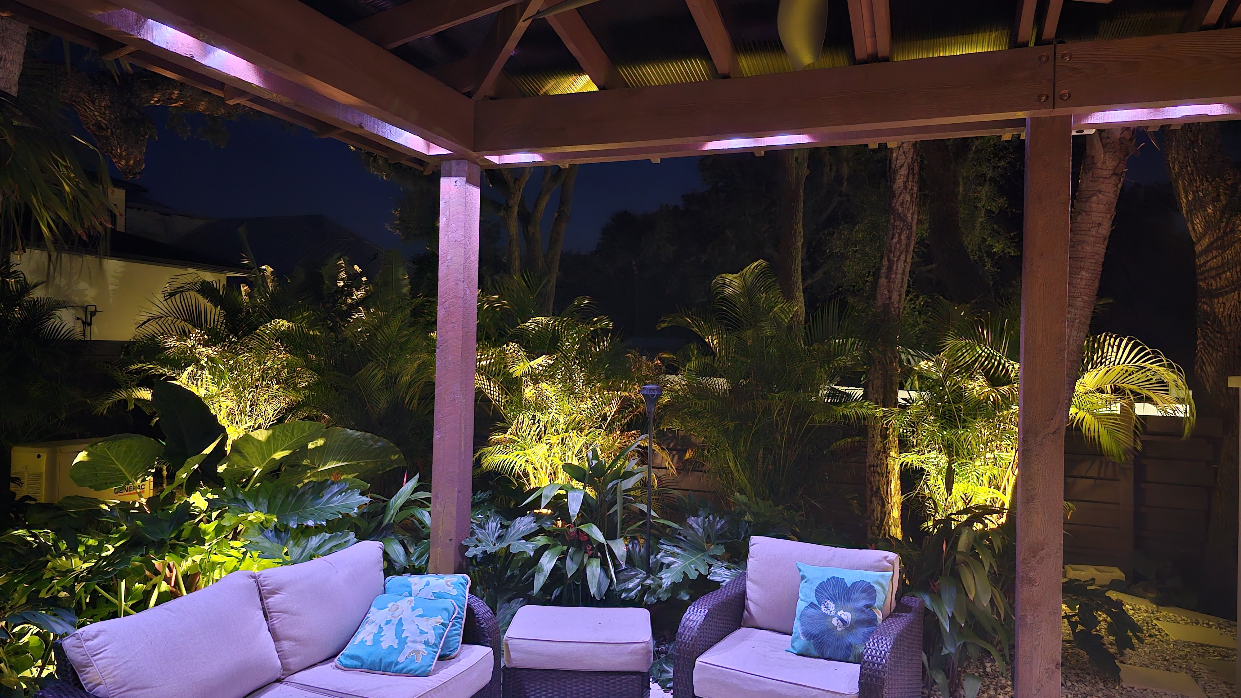 Pergola lounge area with warm ambient outdoor living lighting and landscape accents