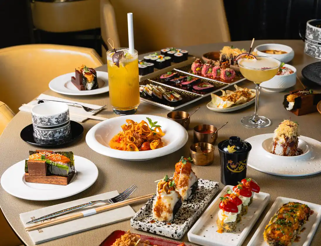 A set round table: maki, sushi, cocktails and hot dishes