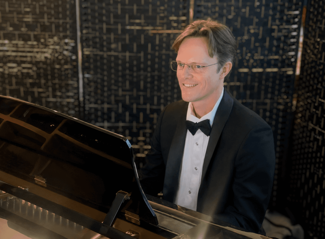 Dustin Callahan playing piano in his studio