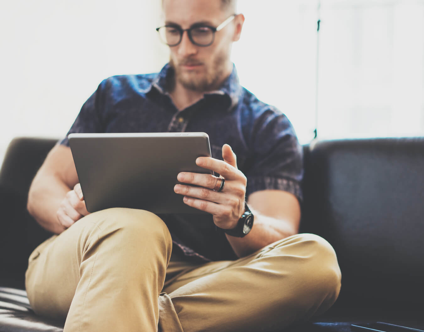 Man using a digital tablet while sitting on a couch