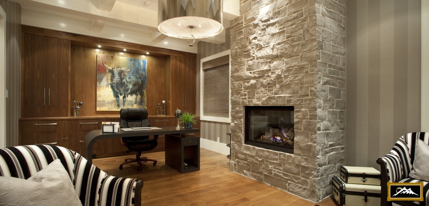 Image of Luxury home office with stone fireplace, desk, and comfortable seating, showcasing KHD Homes design expertise.