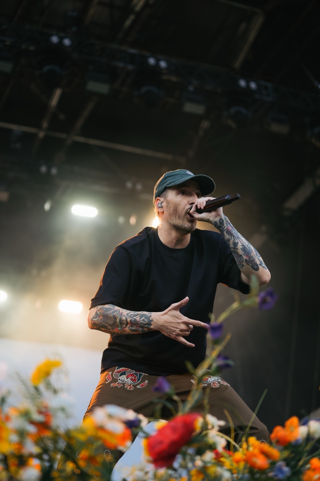Casper am Mikrofon auf der Buehne, Blumen im Vordergrund