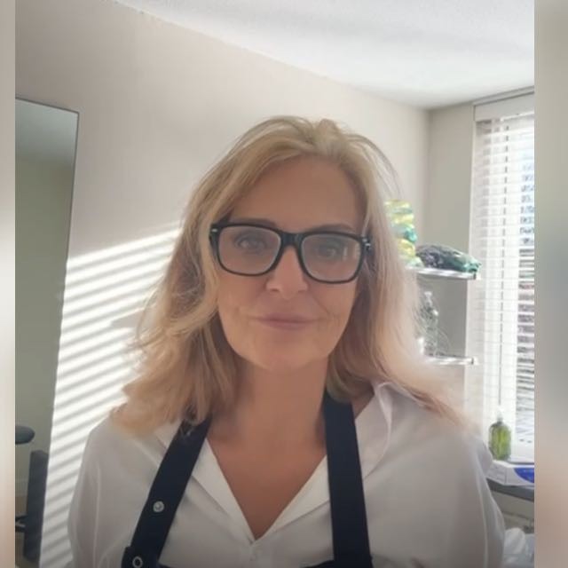 Portrait of a person in a pink sweater against a light background