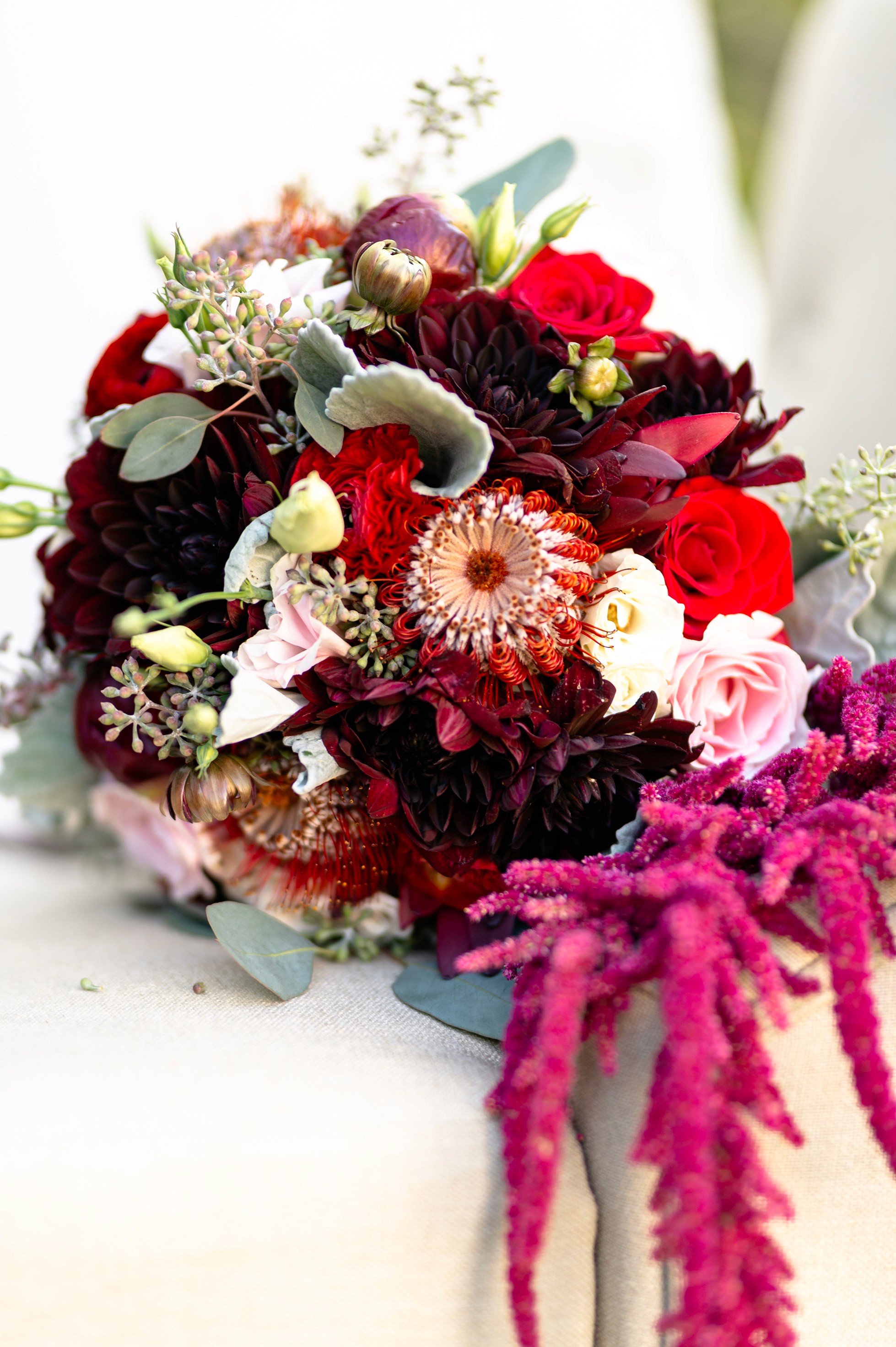Flat lay wedding details with bouquet, rings, and sparkling bridal heels