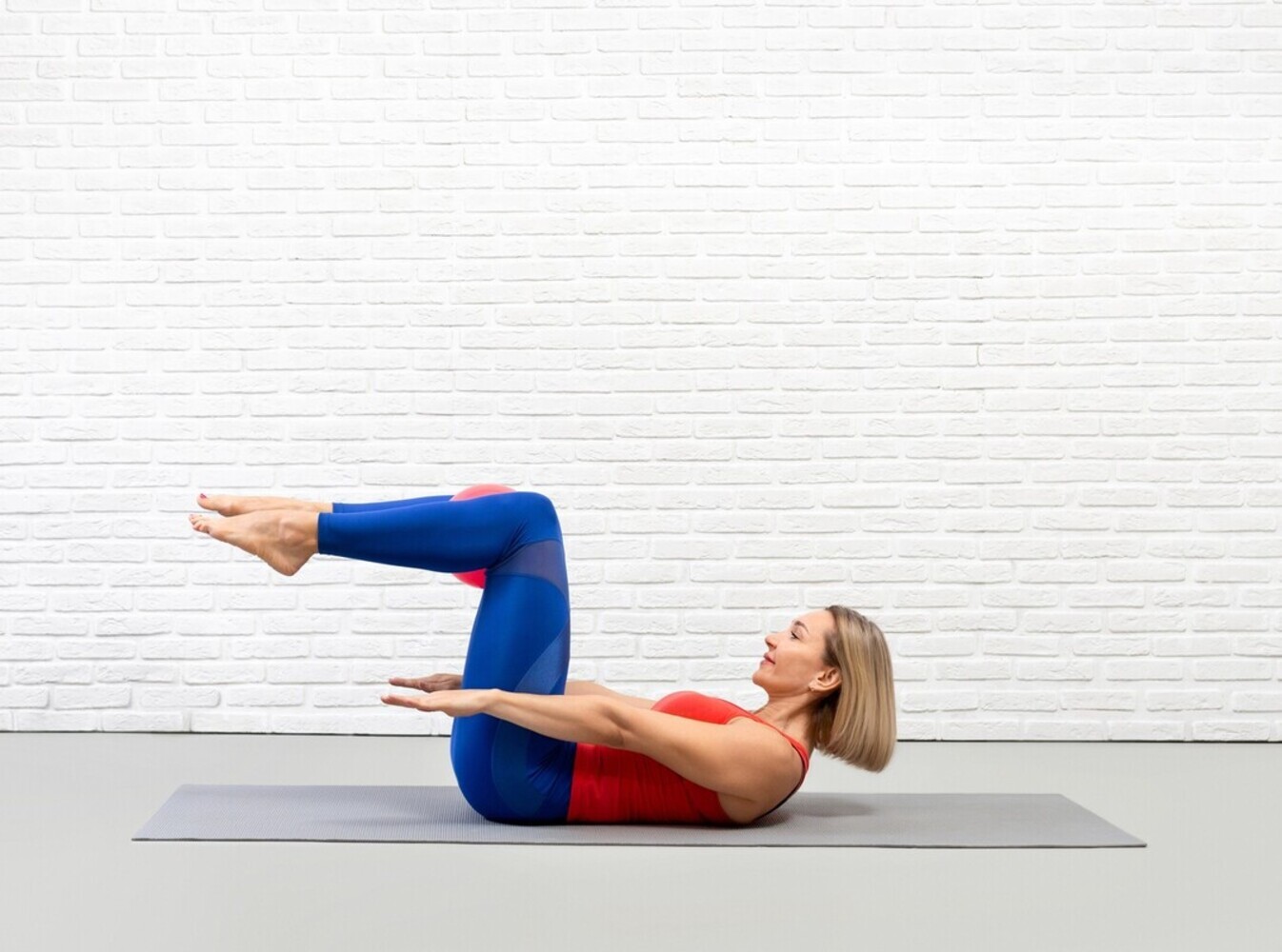 woman doing the hundred exercise during the best pilates workout for weight loss
