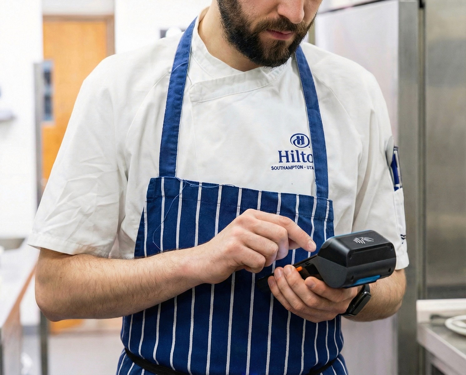 A chef in a commercial kitchen using a Labl.it device to print out a food label.