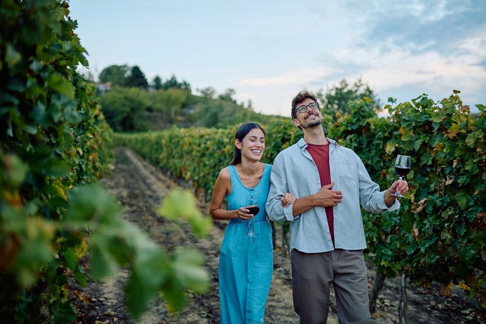 Couple strolling through vineyards with a glass of wine from Central California Coast wineries