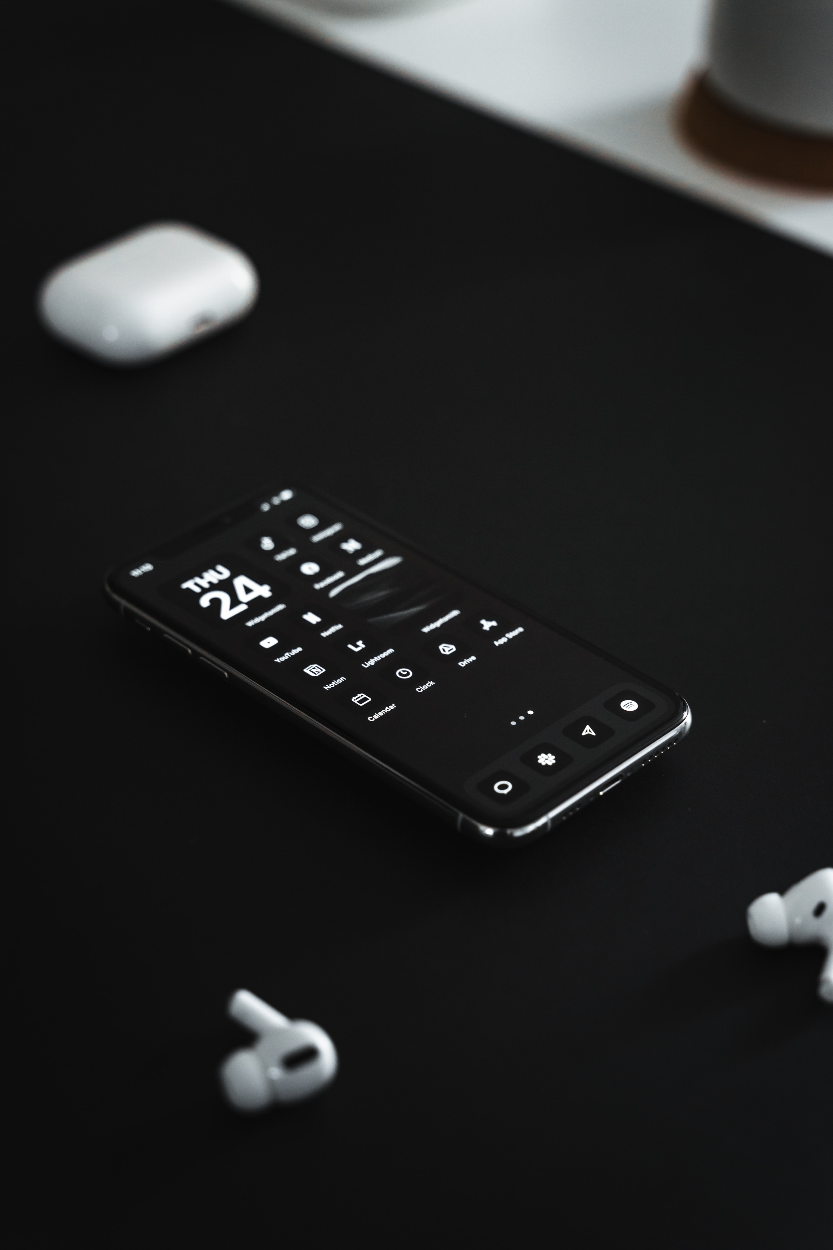 showing a black phone on a black table with black wallpaper and white icons