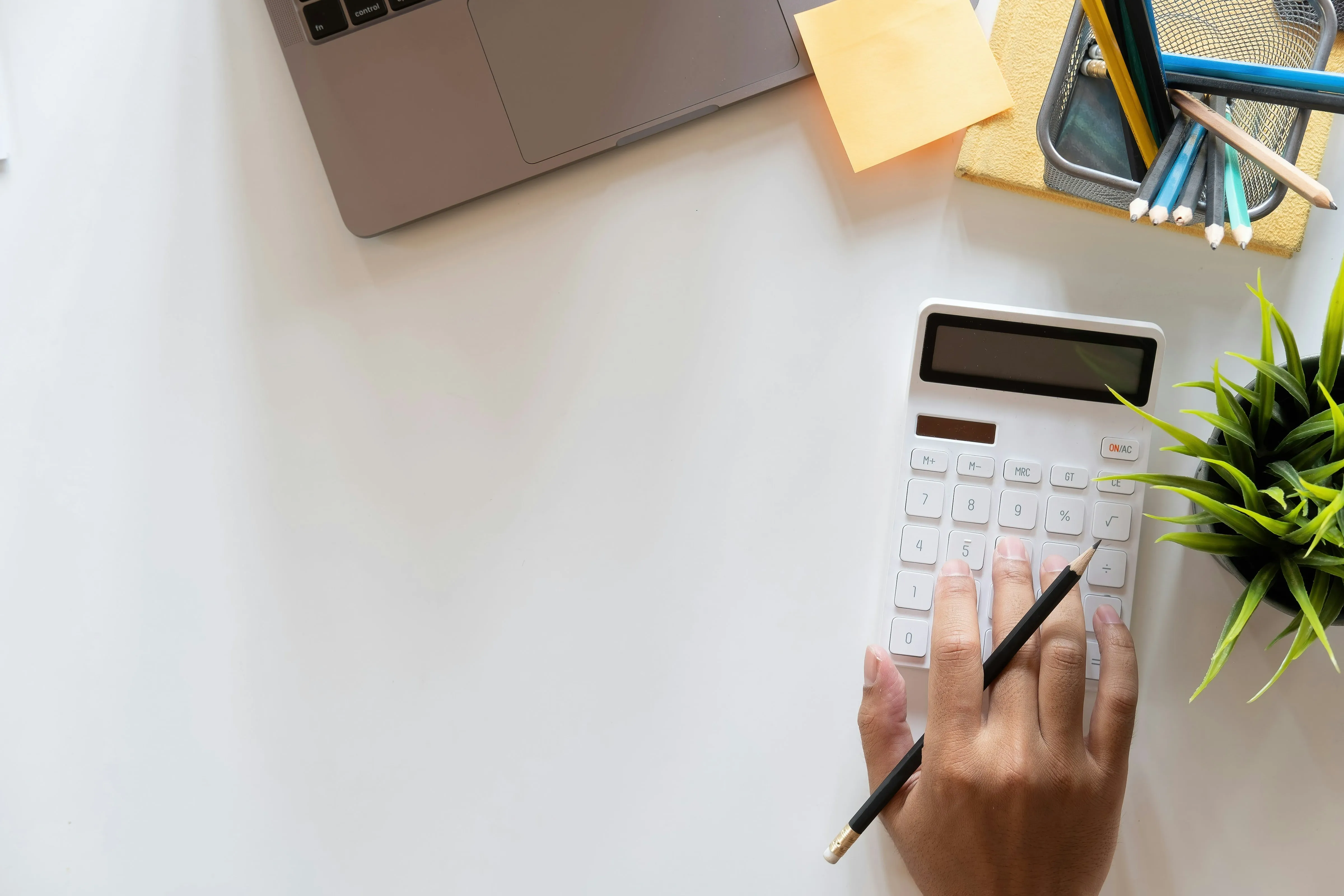 a calculator sitting on top of a table next to a laptop