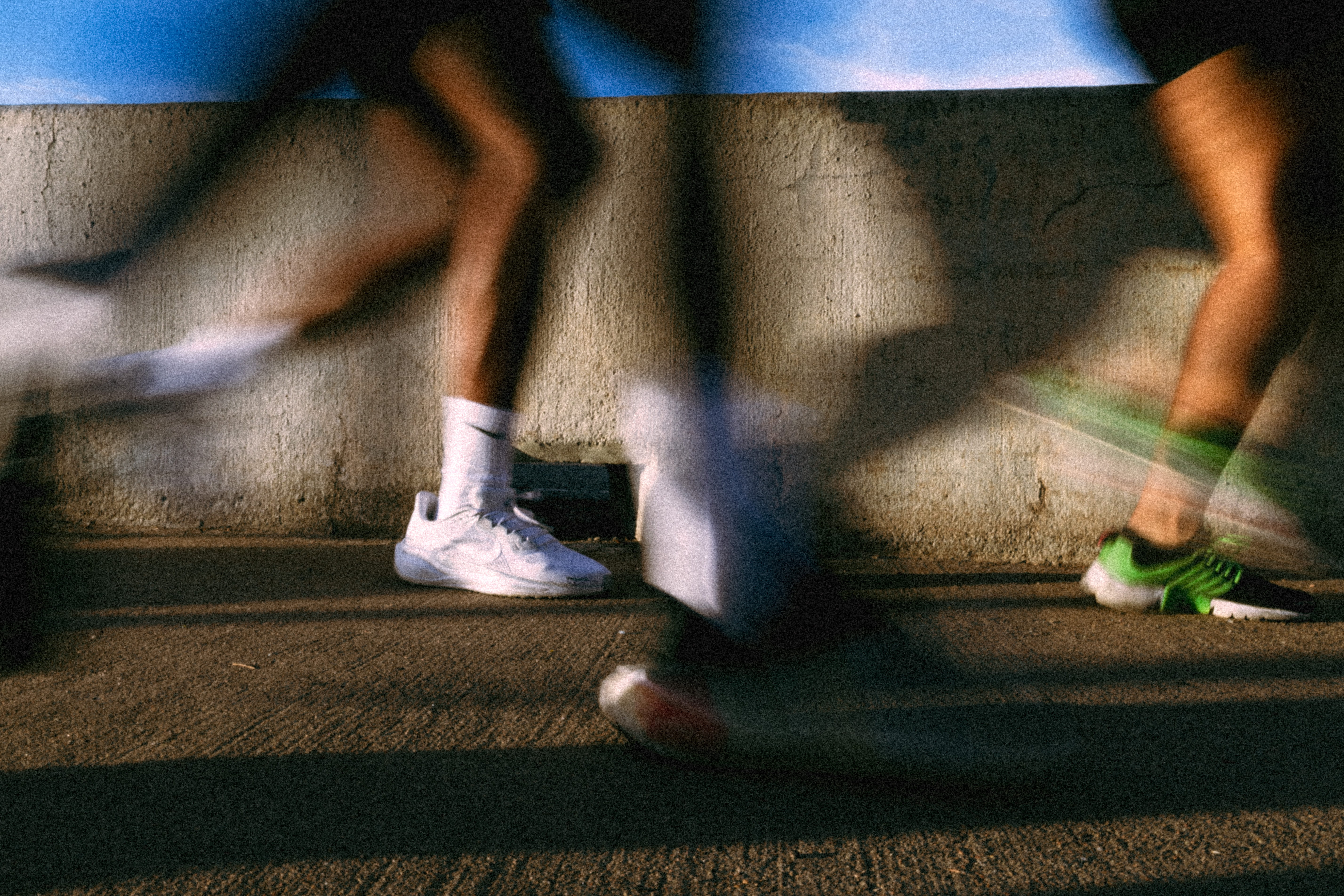 motion-blurred legs and running shoes of endurance run club members during a group run