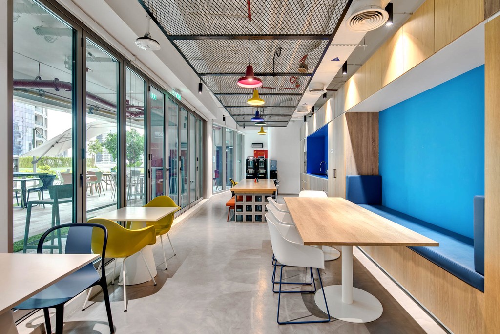The Binary by OMNIYAT's conference room, equipped with blue chairs and a distinctive circular light fixture.