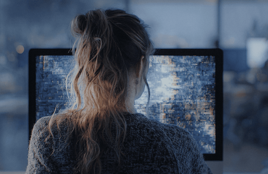Mulher de costas observando uma tela de computador com dados abstratos e distorcidos, representando o risco da IA generativa e da Shadow AI no ambiente jurídico.