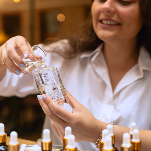 Isang kalahok ang nagbubuhos ng sariling timpla ng pabango sa isang bote na may label na 'Istanbul Workshops' sa isang praktikal na workshop