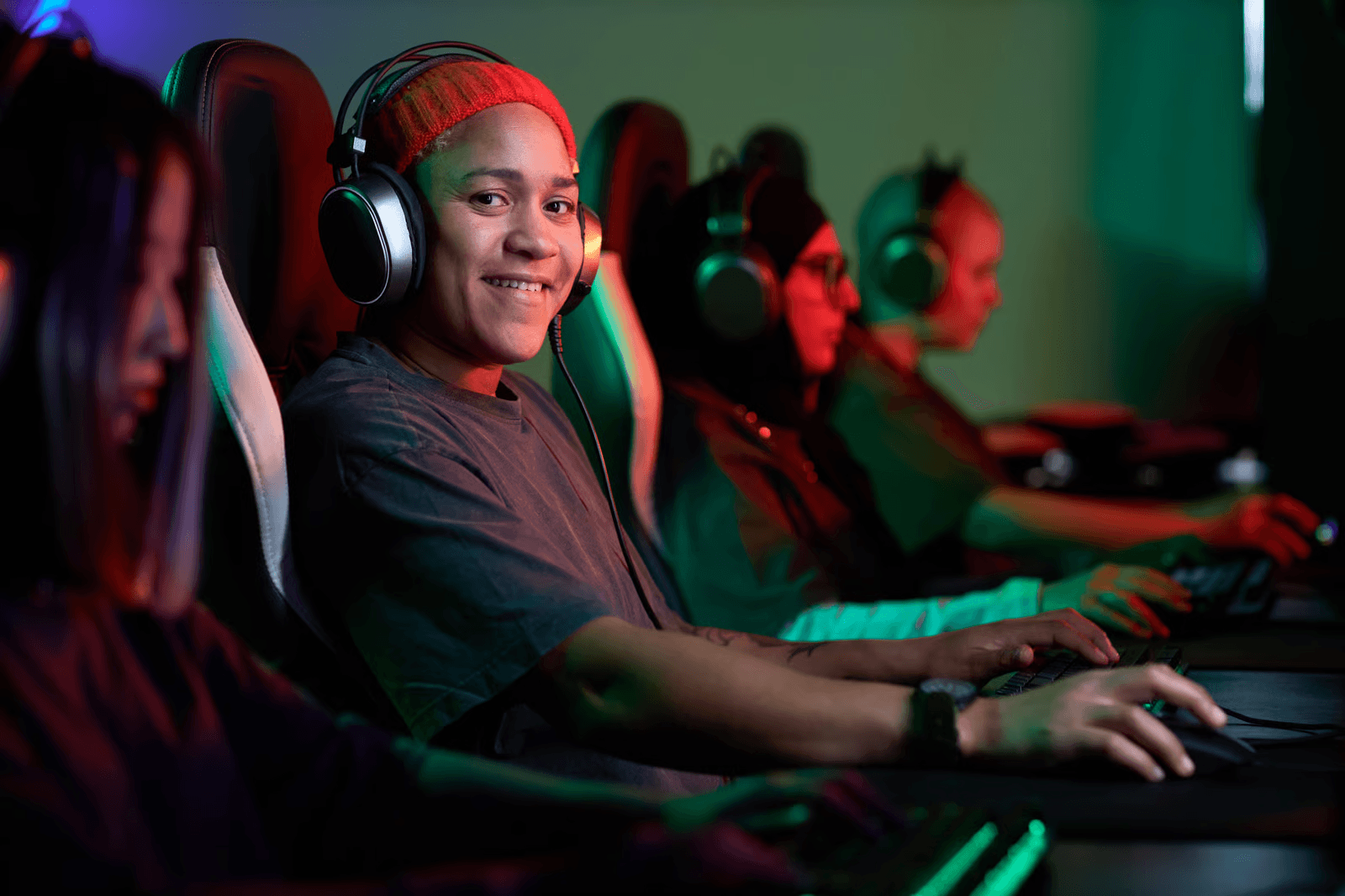 A group of esports players wearing headsets and playing together at gaming computers.