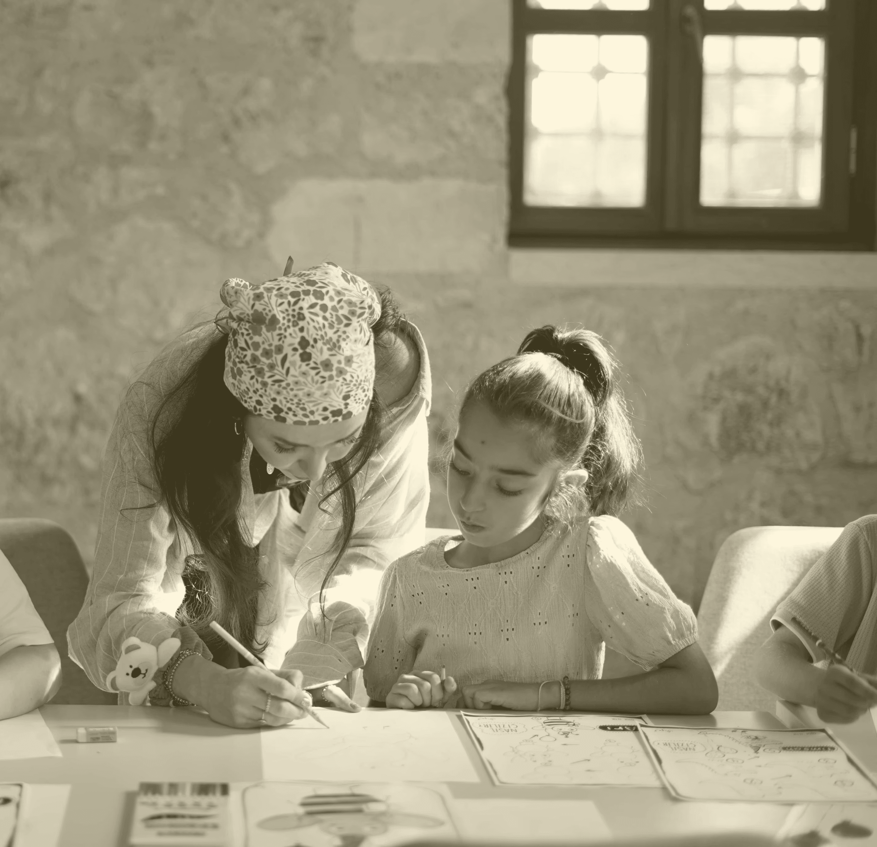 Bir kız çocuğu ve yetişkin bir kadın, beraber yazı etkinliği yapıyor