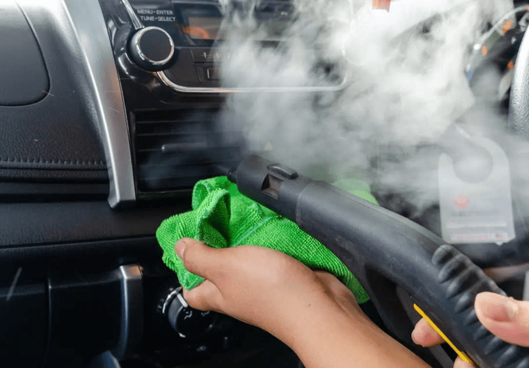 Man cleaninbg car with steamer machine