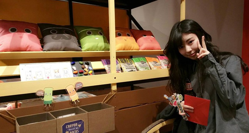 asian woman in front of pillow shelves