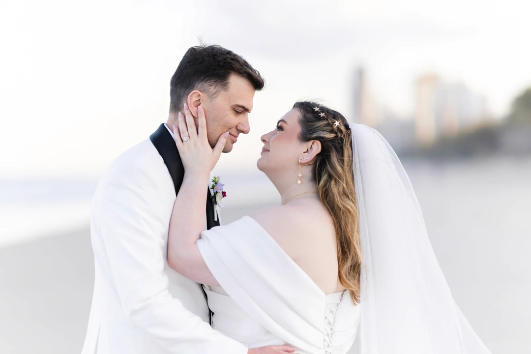 Bride and groom caressing each other on the beach