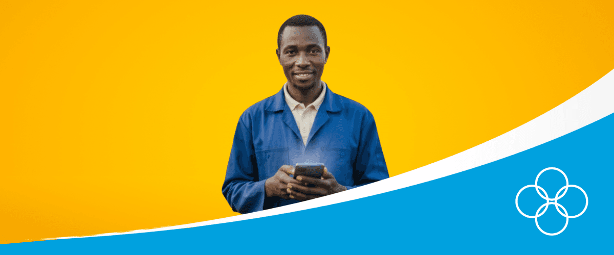 Poultry farmer in a blue overall with a phone in his hand with 123POULTRY app on his screen