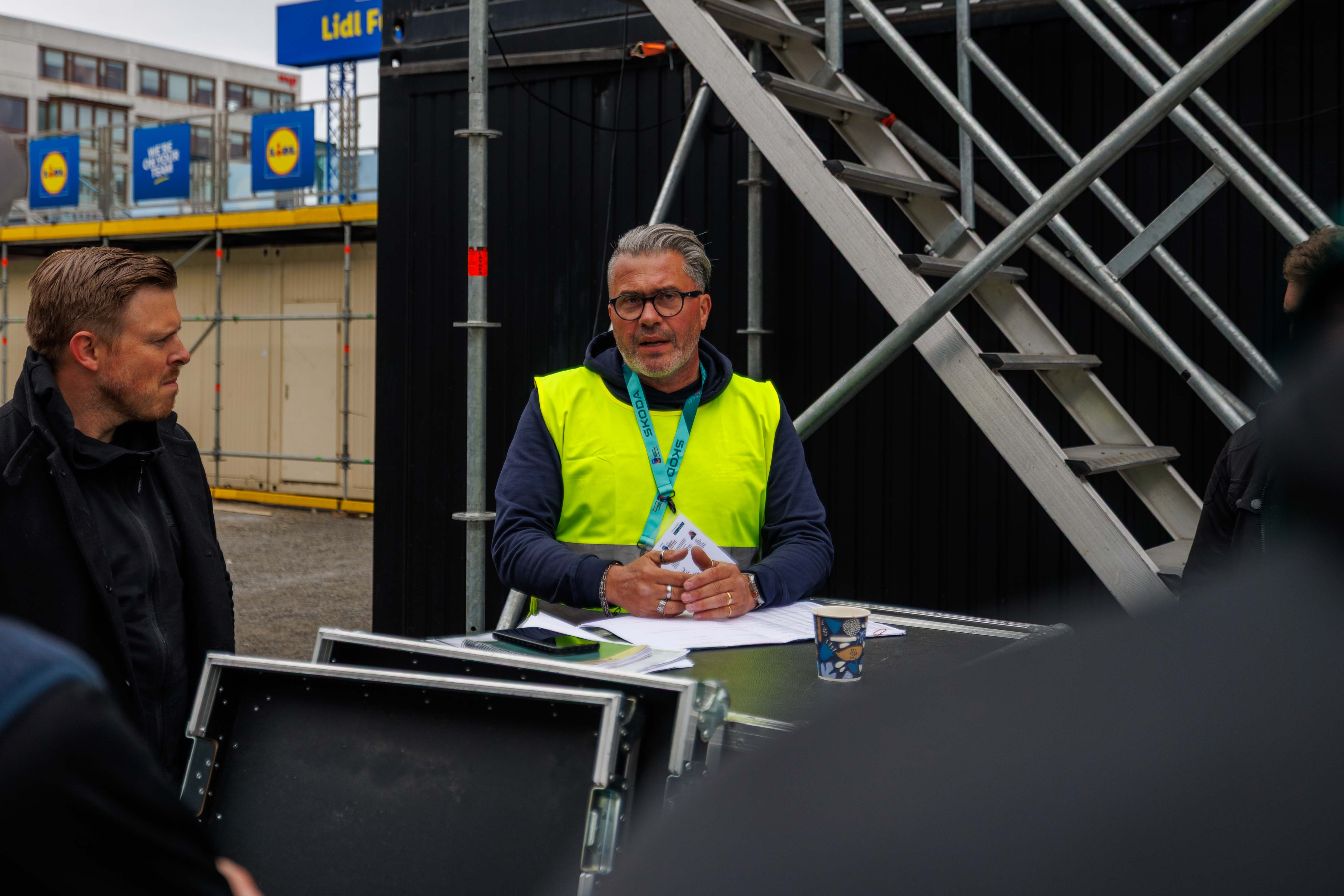 Creative Technology team lead giving a briefing onsite during the massive production setup for the 2025 IIHF World Championship.
