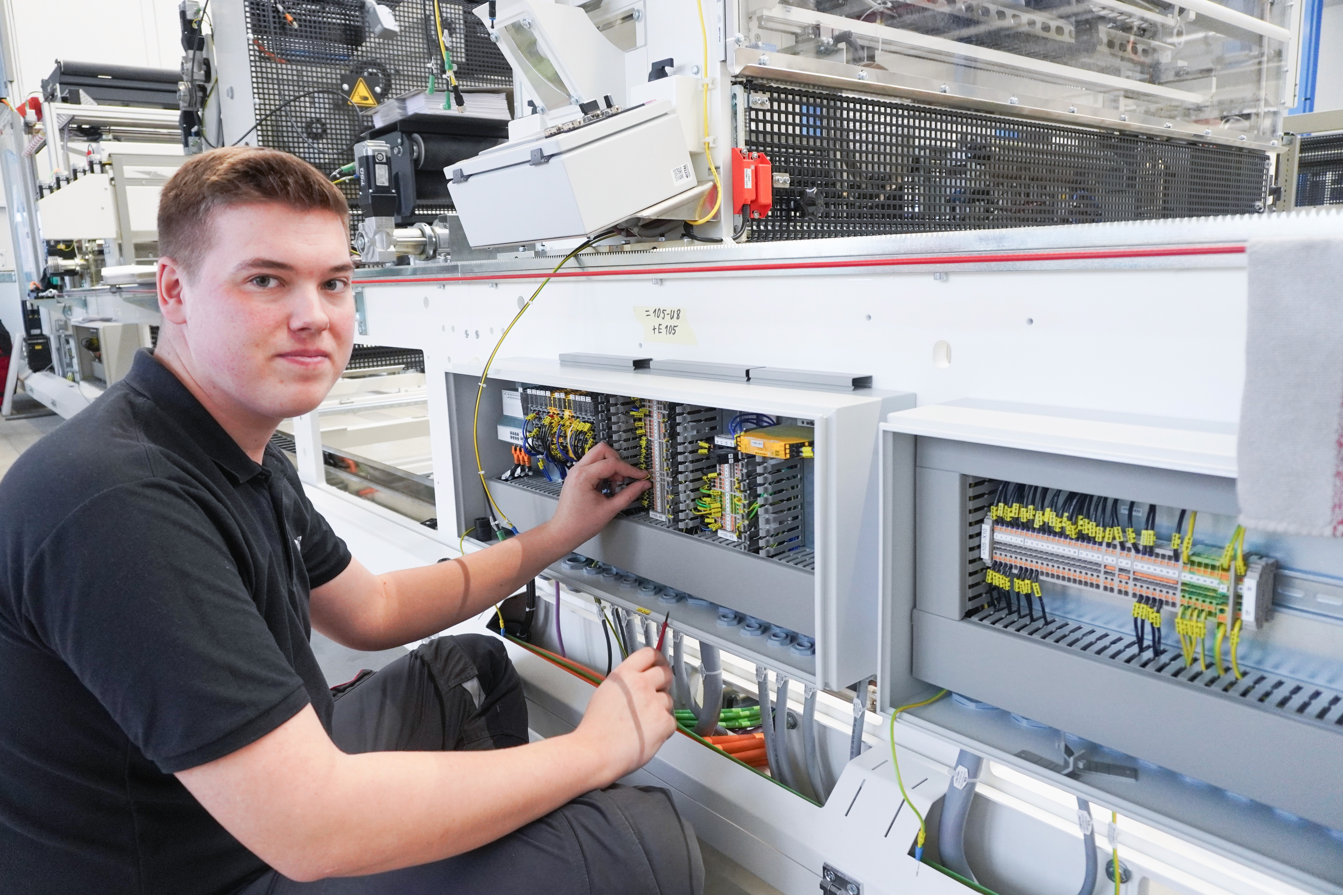 Electrician working on a machine in a factory. Maintenance and upkeep.