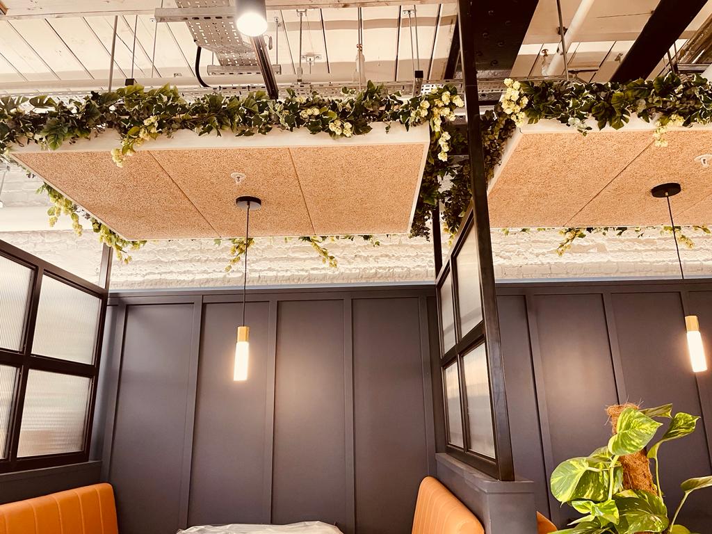 Acoustic panels over bespoke seating with suspended planting feature to create biophilic elements