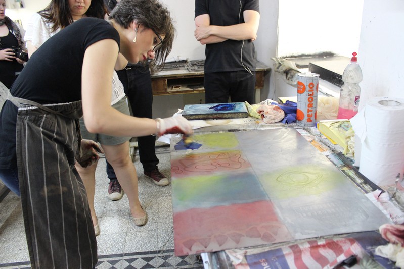 woman making a prints in studio with students watching