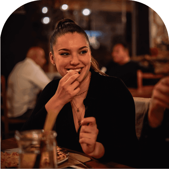 Woman at a restaurant smiling enjoying cashback on her meal with Chest