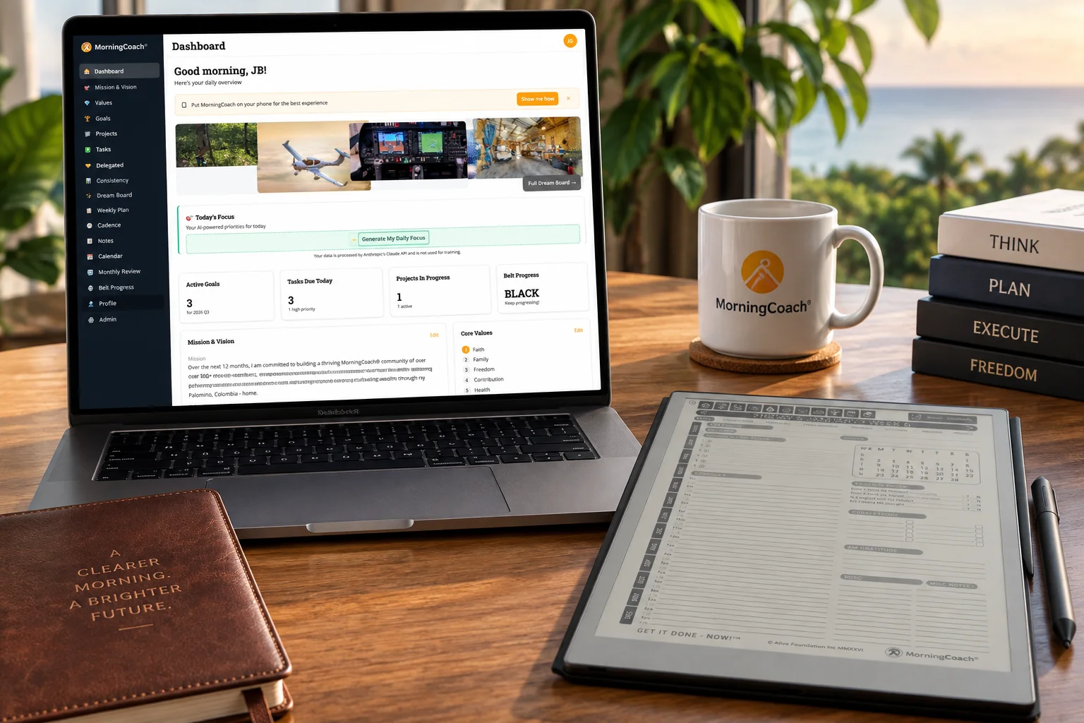 MorningCoach dashboard open on a laptop beside a branded mug and e-ink planner tablet