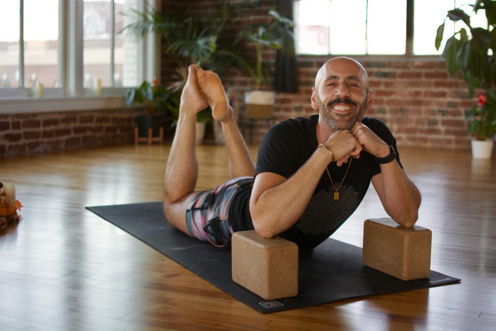 Danny in a yoga pose with blocks on a mat