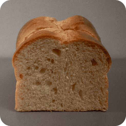 Rebanada frontal de brioche de masa madre dulce, miga suave y bien fermentada.