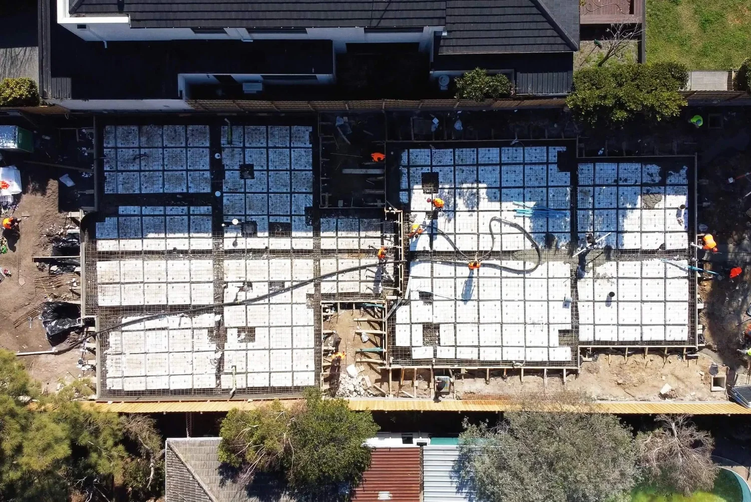 Aerial view of construction site with workers and concrete foundation.