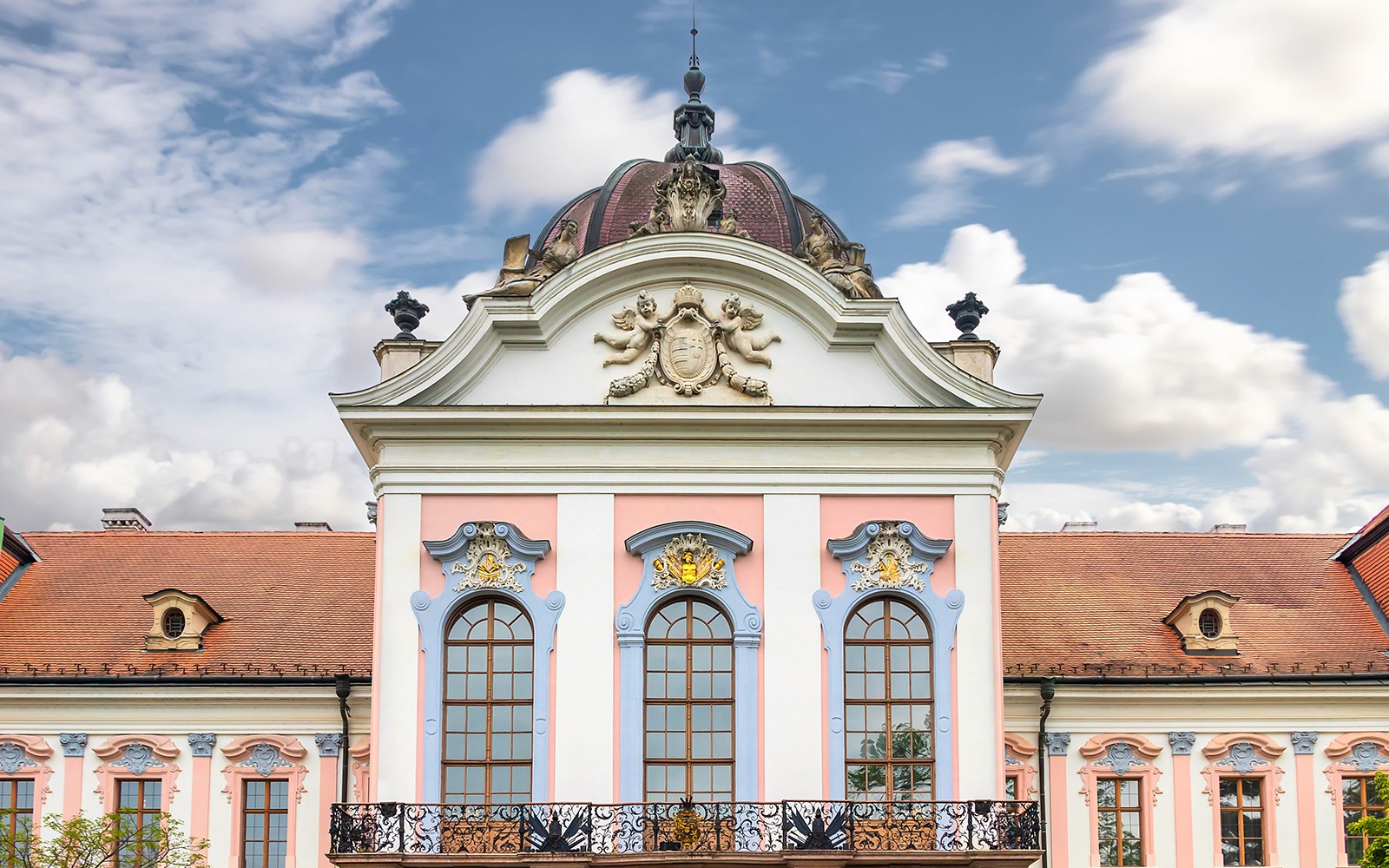 Gödöllő Royal Palace facade with ornate windows and decorative elements, Hungary.