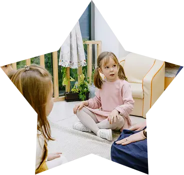 Caring daycare teacher reading aloud to a group of attentive toddlers