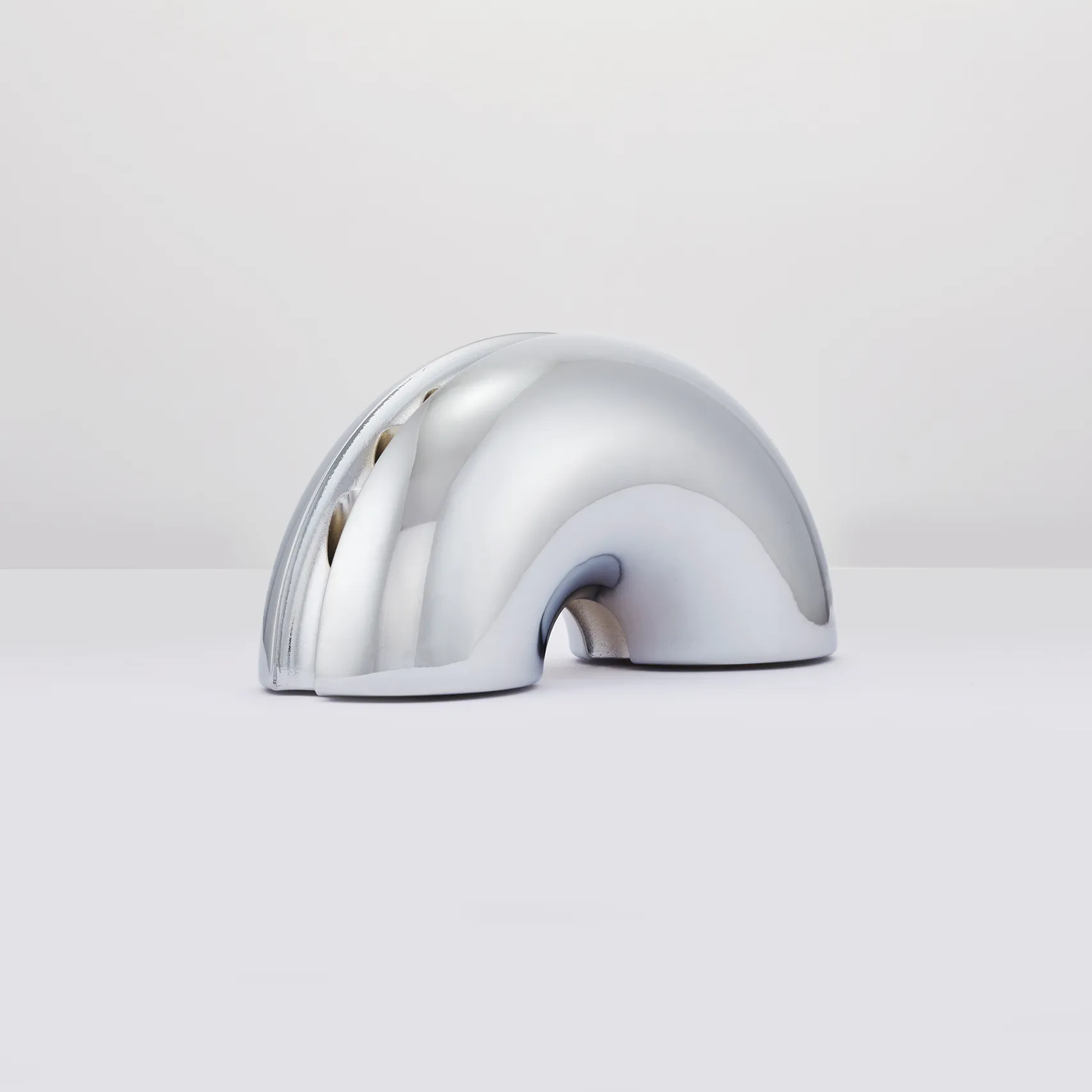 Polished silver Nosh Menorah form study on a light gray background