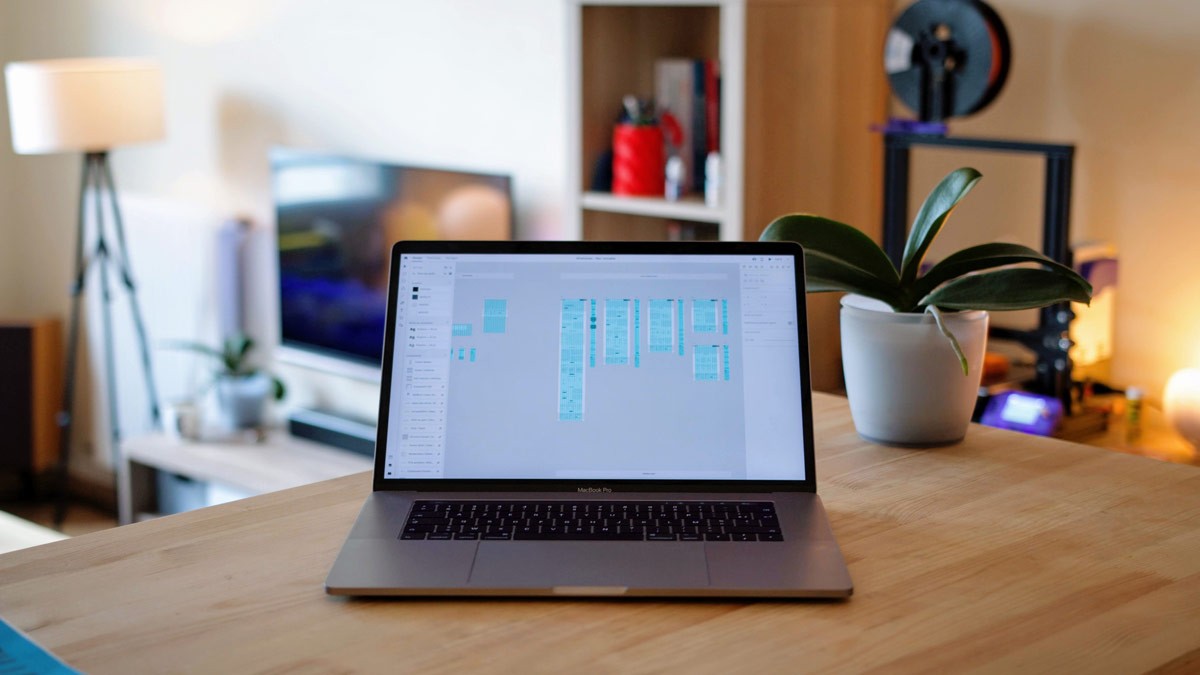 A laptop displaying wireframes designed in Figma