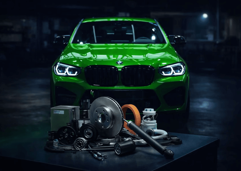 Green car with auto parts in front