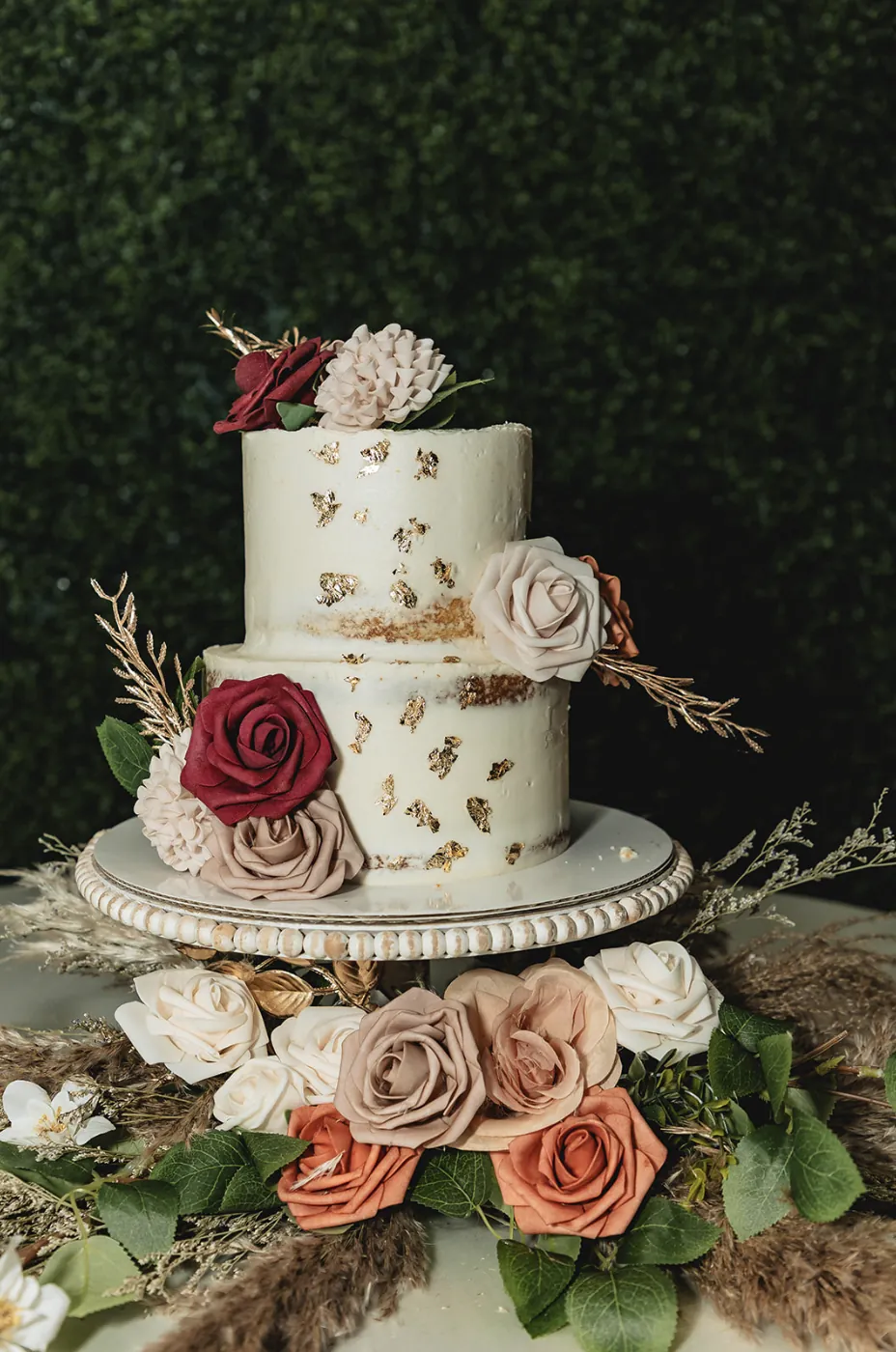 A vibrant bridal bouquet featuring a mix of red, pink, and purple flowers.