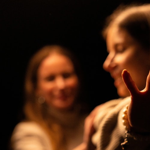 Two women move cautiously through the darkness.