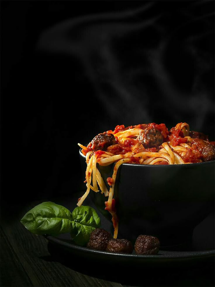 Steaming pasta dish photographed in dramatic lighting, illustrating the global influence and visual sophistication that align with Michelin level dining standards.