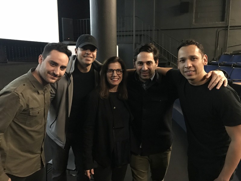 A photo of a group of people standing in a theater room.