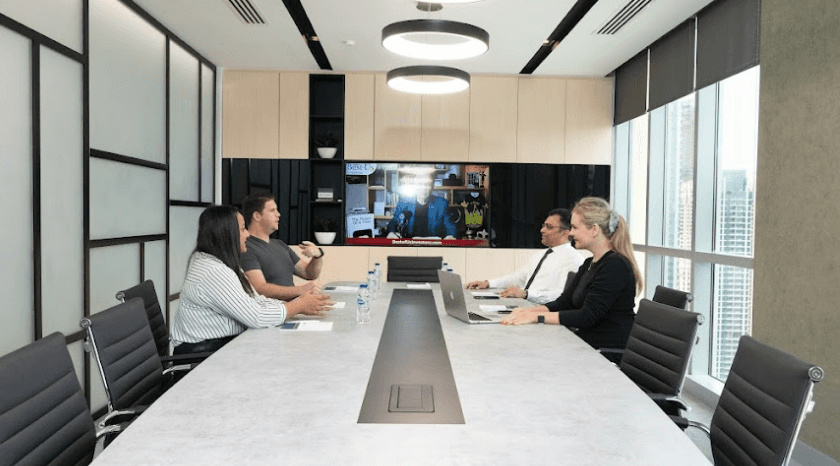 A group of professionals discussing VAT registration steps at a conference table in Dubai, by myOffice