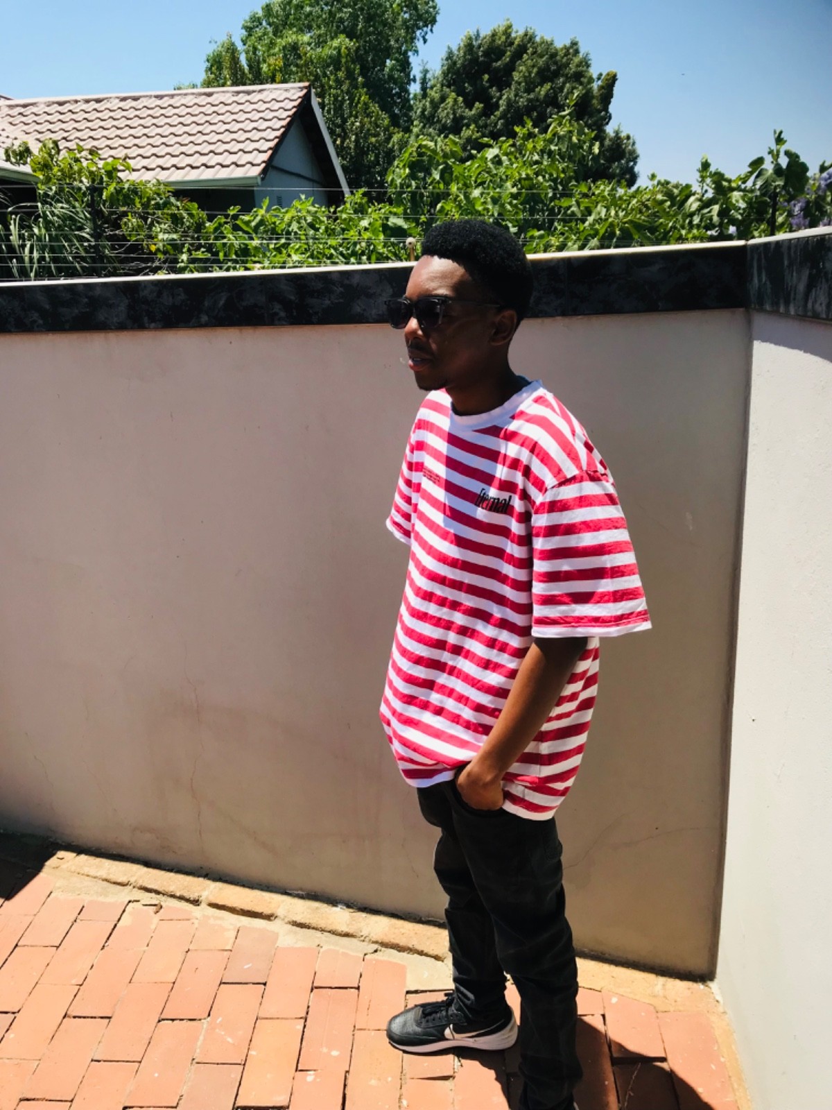 A thoughtful young person with dark hair gazes to the side, captured in soft black and white lighting.