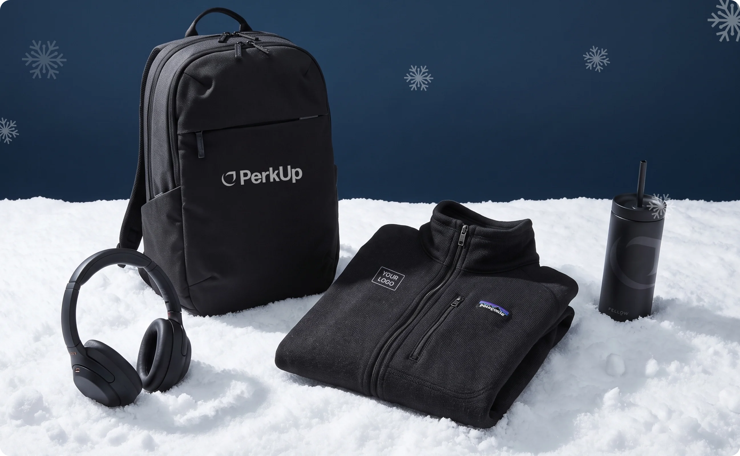A backpack, a headset, and a jacket laid out on the snow.