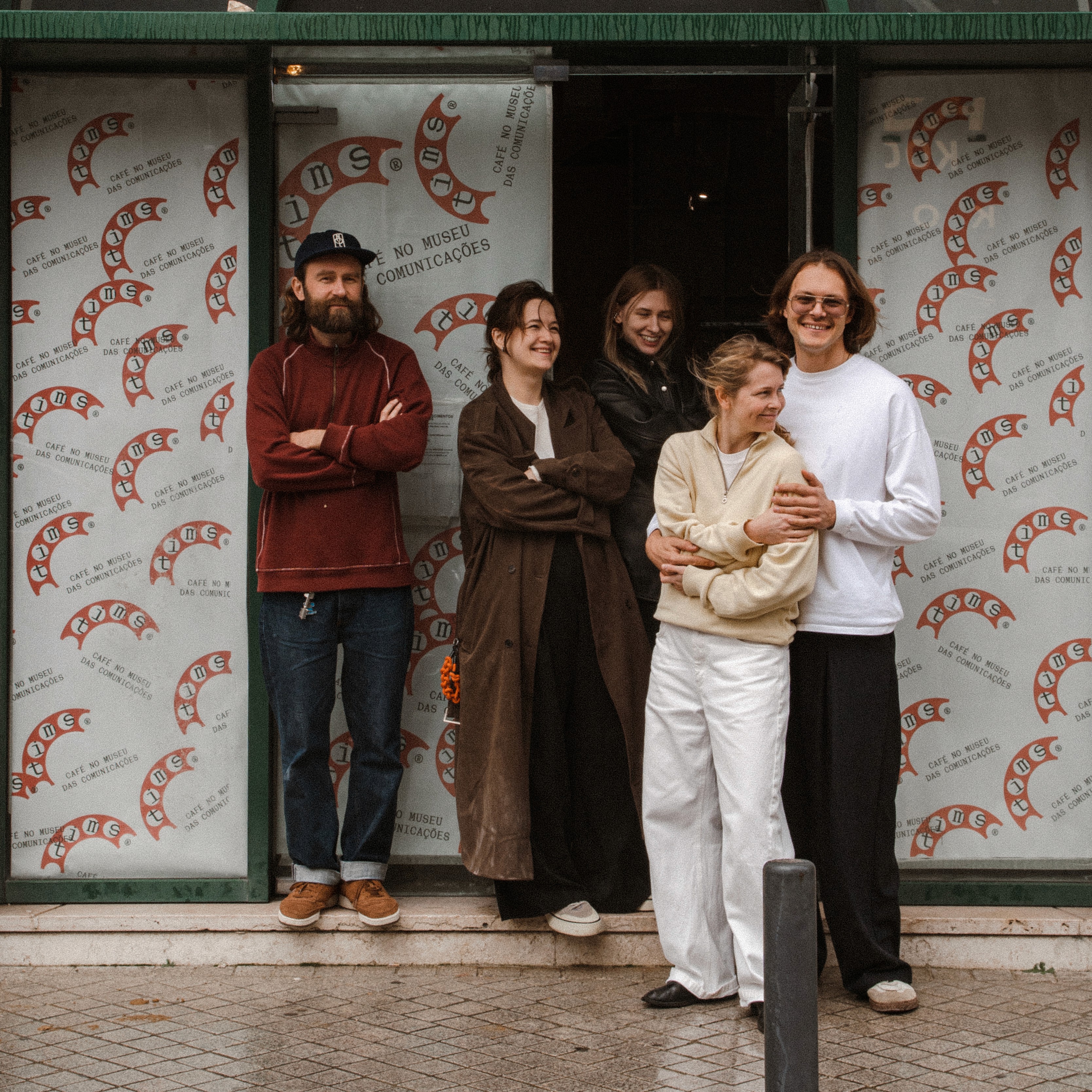 Person wearing a beige apron whisking green matcha tea in a ceramic bowl on a kitchen counter.