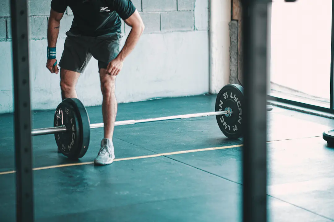 Mężczyzna stojący nad sztangą