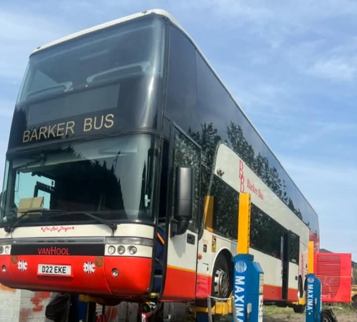 Barker Bus double-decker coach raised on mobile vehicle lifts.